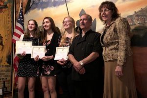 Three studetns are award money from the Don Quijote Scholarship Fund