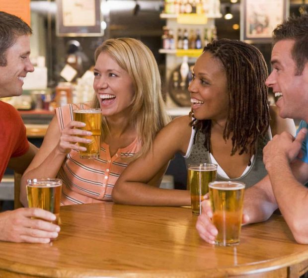 Group of young friends drinking and laughing in a bar Located near the Valpo Restaurants and year-round activity makes Uptown a great place for 2 bedroom apartments for rent